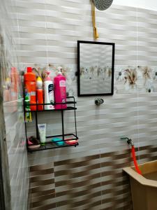 - une salle de bains pourvue d'une étagère avec des produits d'entretien dans l'établissement Rizki Homestay, à Nibung Tebal
