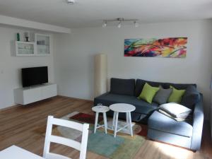 Una sala de estar con un sofá azul y una mesa. en Ferienwohnung am Argental, en Wangen im Allgäu