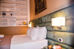 a hotel room with a bed with white pillows at Sweet Home Parioli in Rome