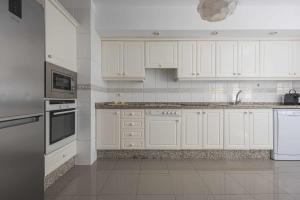 Biała kuchnia z białymi szafkami i urządzeniami w obiekcie Terraza de Radazul w mieście Radazul