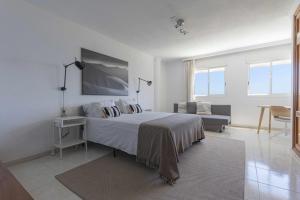 biała sypialnia z łóżkiem i kanapą w obiekcie Terraza de Radazul w mieście Radazul