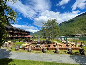 a park with benches and tables and a mountain at Flåmsbrygga Hotel in Flåm