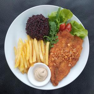 a plate of food withfried chicken and french fries and sauce at Charlie's Angels Hotel Restaurant in Rawai Beach