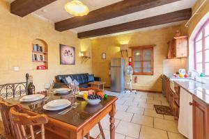een keuken en een woonkamer met een houten tafel met stoelen bij Gozitan Farmhouse with Pool - PP 1 in Il-Wilġa