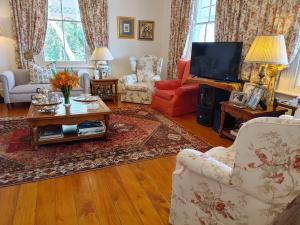 a living room filled with furniture and a tv at Yellowwood Lodge in Knysna