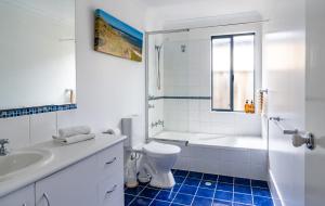 een witte badkamer met een toilet en een wastafel bij Lime Tree Haven in Margaret River Town +6 foto's