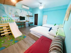 a bedroom with two beds and a room with a slide at 田中歐寒集b&b in Dongshan