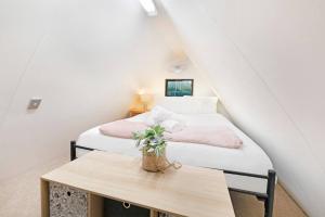 a attic bedroom with two beds and a table at 'Bluey' a Tiny House A-frame Moments to Foreshore in Nightcliff