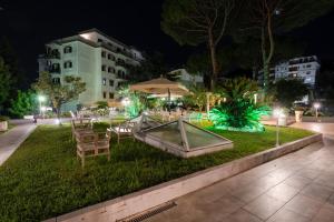 un parque con mesas y sillas por la noche en Giardino Archeologico, en Sorrento