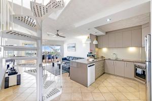 une cuisine ouverte et un salon dans une maison dans l'établissement Cullen Bay Penthouse with Pool, Decks and Marina Views, à Larrakeyah