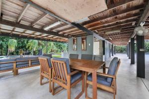an outdoor dining room with a wooden table and chairs at A Tropical Pool Paradise in Rapid Creek in Nightcliff