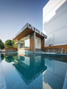 a house with a swimming pool in front of it at Prime Square Hotel in Chiang Mai