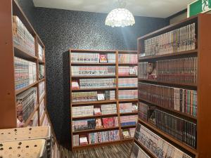 a library with many shelves of dvds at Hotel ニャンだふる in Himeji