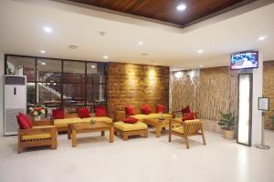 um átrio com sofás e almofadas vermelhas em Kautaman Hotel em Mataram