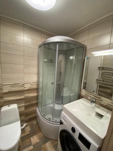 a bathroom with a shower and a toilet and a sink at Прелестное жильё у Akropole, бесплатная парковка. in Rīga