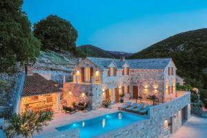 una vista aérea de una casa con piscina en New Villa Ani! Traditional and luxurious 4-bedroom villa with heated pool and sea views, en Postira
