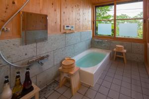スイートヴィラ オーシャンビュー熱海⾃然郷 في أتامي: حمام كبير مع حوض ومغسلة