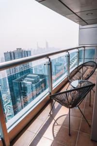 balcón con silla y vistas a la ciudad en Two Continents Holiday Homes - Penthouse on 71st floor - Princess Tower en Dubái