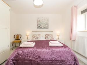 a bedroom with a purple bed with two pillows at Camden Cottage in Kidderminster