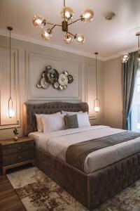 a bedroom with a large bed and a chandelier at Two Continents Holiday Homes - Penthouse on 71st floor - Princess Tower in Dubai