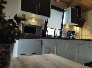 a kitchen with white appliances and a wooden table at Cztery Pory Roku - kominek, sauna, jacuzzi in Zarzecze