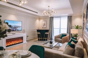 a living room with a couch and a fireplace at Two Continents Holiday Homes - Penthouse on 71st floor - Princess Tower in Dubai