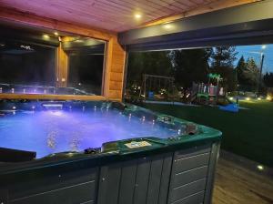 a jacuzzi tub in a backyard at night at Cztery Pory Roku - kominek, sauna, jacuzzi in Zarzecze