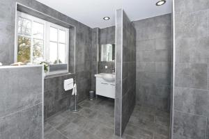 a gray bathroom with a sink and a mirror at STöRTEBEKER APPARTEMENTS - "BLAUES HAUS" in Ralswiek