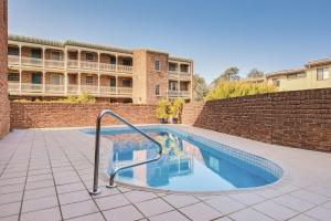 a swimming pool with a hand rail in front of a building at Adina Serviced Apartments Canberra Kingston in Canberra
