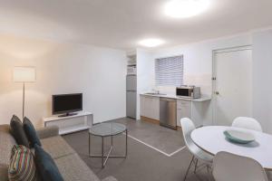 - un salon avec un canapé et une table dans l'établissement Adina Serviced Apartments Canberra Kingston, à Canberra