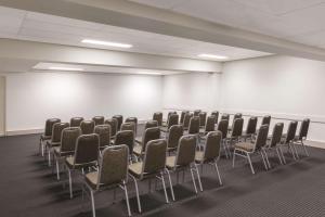 an empty room with chairs and a white wall at Adina Serviced Apartments Canberra Kingston in Canberra +25 photos