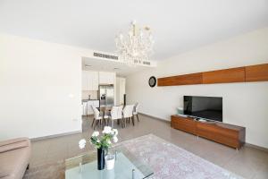 a living room with a chandelier and a table at Spacious & Private Townhome - 5 mins drive to Al Maktoum Airport in Dubai