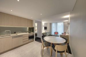 cocina y comedor con mesa y sillas en Adina Apartment Hotel Bondi Beach Sydney, en Sídney