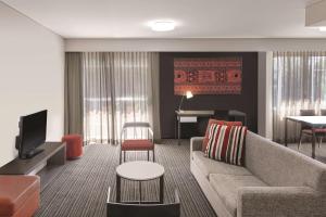 - un salon avec un canapé et un piano dans l'établissement Adina Apartment Hotel Darwin Waterfront, à Darwin