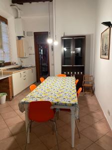 - une table à manger avec des chaises orange dans la cuisine dans l'établissement Artemisia, à Pise