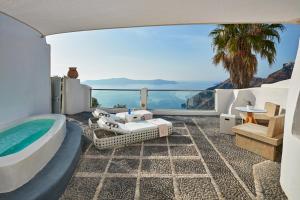 a villa with a tub and a view of the ocean at Belvedere Suites in Firostefani