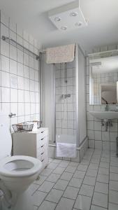 a white bathroom with a toilet and a sink at Gartenhaus - a68978 