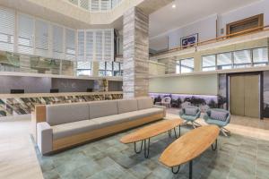 a lobby with a couch and two chairs at Vibe Hotel Gold Coast in Gold Coast