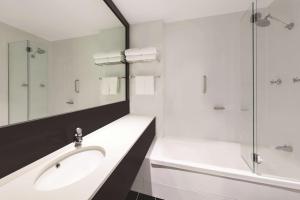 a bathroom with a sink and a shower and a tub at Vibe Hotel Gold Coast in Gold Coast