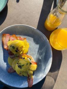 a plate of food with bacon and fruit on it at Le Petit Manoir Boutique Hotel in Franschhoek