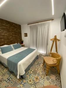 een slaapkamer met een groot bed en een stoel bij HOSTAL LA BATUTA in Mogente