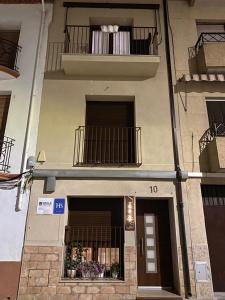 een gebouw met 2 balkons en een deur met bloemen bij HOSTAL LA BATUTA in Mogente