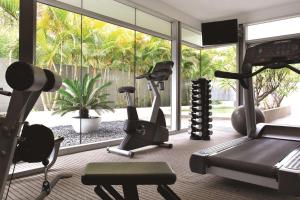 a gym with exercise equipment and a large window at Adina Apartment Hotel Perth in Perth