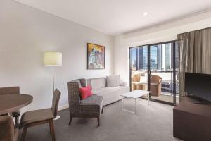 a living room with a couch and a table at Adina Apartment Hotel Perth Barrack Plaza in Perth