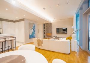 a living room with a white couch and a kitchen at Bluewaters Residences, Bluewaters Island Dubai - Mint Stay in Dubai