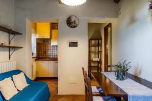 un soggiorno con divano blu e tavolo di La Cisterna a Civitella Marittima