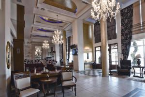 - un hall avec des lustres, des tables et des chaises dans l'établissement Phaidon Hotel & Spa, à Flórina