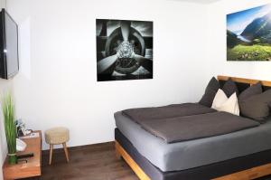 カプルーンにあるAppartement Kaprun4Youのベッドルーム1室(ベッド1台付)が備わります。壁に絵が飾られています。