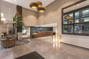 a lobby of a restaurant with a person in the background at Adina Apartment Hotel Auckland Britomart in Auckland