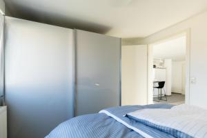 a bedroom with a blue and white bed and a mirror at Appartement Burgund in Oedheim